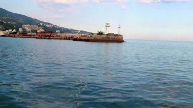 Geminin hareketinden kaynaklanan suda ayak izleri ve Yalta, Kırım şehrinin manzarası.