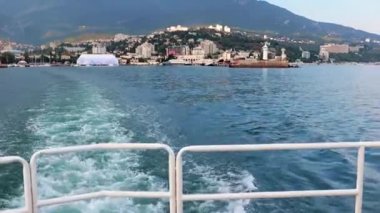Geminin hareketinden kaynaklanan suda ayak izleri ve Yalta, Kırım şehrinin manzarası.