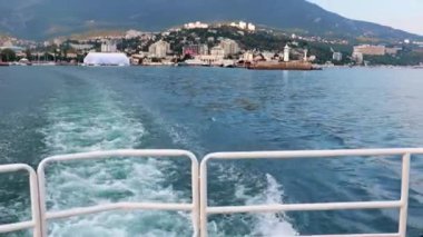Geminin hareketinden kaynaklanan suda ayak izleri ve Yalta, Kırım şehrinin manzarası.
