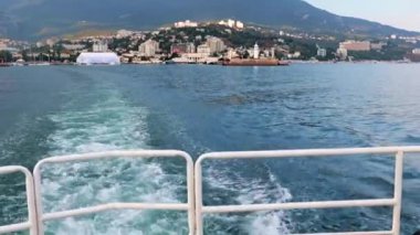 Geminin hareketinden kaynaklanan suda ayak izleri ve Yalta, Kırım şehrinin manzarası.