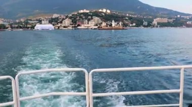 Geminin hareketinden kaynaklanan suda ayak izleri ve Yalta, Kırım şehrinin manzarası.