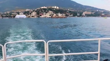 Geminin hareketinden kaynaklanan suda ayak izleri ve Yalta, Kırım şehrinin manzarası.