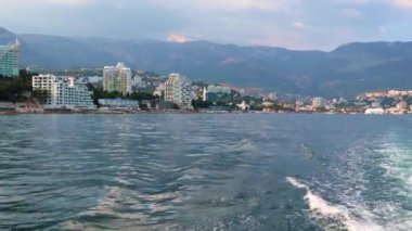 Geminin hareketinden kaynaklanan suda ayak izleri ve Yalta, Kırım şehrinin manzarası.