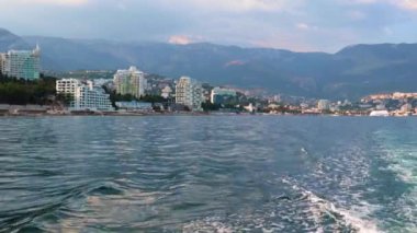 Geminin hareketinden kaynaklanan suda ayak izleri ve Yalta, Kırım şehrinin manzarası.