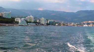 Geminin hareketinden kaynaklanan suda ayak izleri ve Yalta, Kırım şehrinin manzarası.