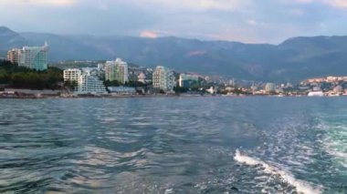 Geminin hareketinden kaynaklanan suda ayak izleri ve Yalta, Kırım şehrinin manzarası.