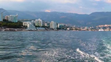 Geminin hareketinden kaynaklanan suda ayak izleri ve Yalta, Kırım şehrinin manzarası.