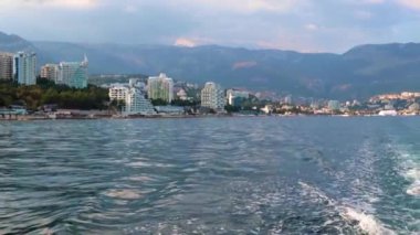 Geminin hareketinden kaynaklanan suda ayak izleri ve Yalta, Kırım şehrinin manzarası.