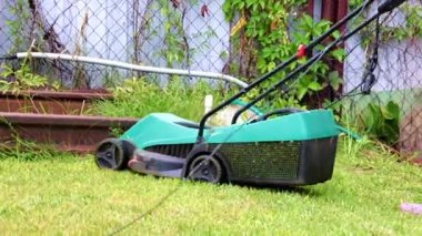 Elektrikli çim biçme makinesiyle taze çim biçiyorum.