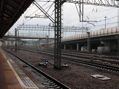 Bulutlu bir akşamda bir yolcu istasyonunun yapıları ve izleri