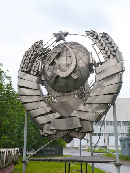 the dismantled coat of arms of the Union of Soviet Socialist Republics stands on the lawn in the Park Moscow Russia, USSR