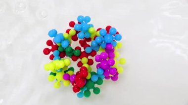 Plastik çocukların inşaat malzemeleri bir su akışında virüs molekülü şeklinde bir araya getirildi.