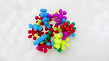 Plastik çocukların inşaat malzemeleri bir su akışında virüs molekülü şeklinde bir araya getirildi.