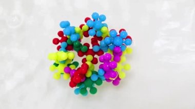 Plastik çocukların inşaat malzemeleri bir su akışında virüs molekülü şeklinde bir araya getirildi.