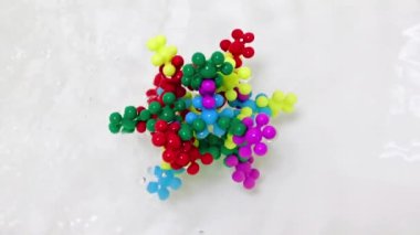 Plastik çocukların inşaat malzemeleri bir su akışında virüs molekülü şeklinde bir araya getirildi.