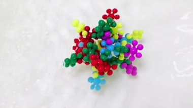 Plastik çocukların inşaat malzemeleri bir su akışında virüs molekülü şeklinde bir araya getirildi.