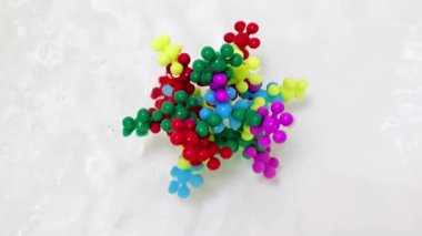 Plastik çocukların inşaat malzemeleri bir su akışında virüs molekülü şeklinde bir araya getirildi.