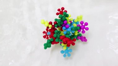 Plastik çocukların inşaat malzemeleri bir su akışında virüs molekülü şeklinde bir araya getirildi.