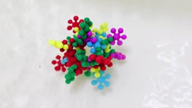 Plastik çocukların inşaat malzemeleri bir su akışında virüs molekülü şeklinde bir araya getirildi.