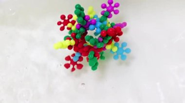 Plastik çocukların inşaat malzemeleri bir su akışında virüs molekülü şeklinde bir araya getirildi.