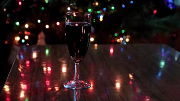 Ein Glas Rotwein Und Silvesterbeleuchtung Weihnachtsbaum — Stockvideo