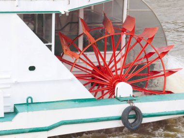 Su, nehir vapurunun çarkının parçalarından akar.