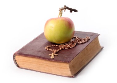 Eski bir Hıristiyan kitabı ve olgun bir elmanın yanında haçla altın bir zincir.