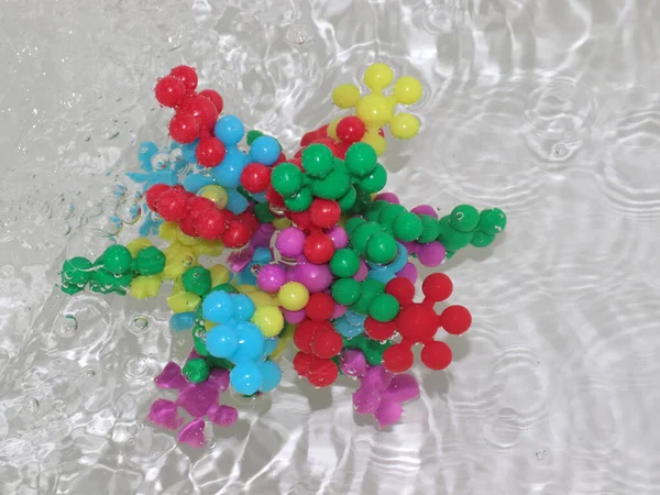 plastic model of a virus in a stream of dirty liquid