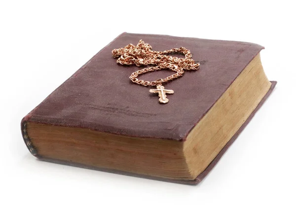 古い本にはキリスト教徒の十字架を持つ金の鎖が置かれています — ストック写真