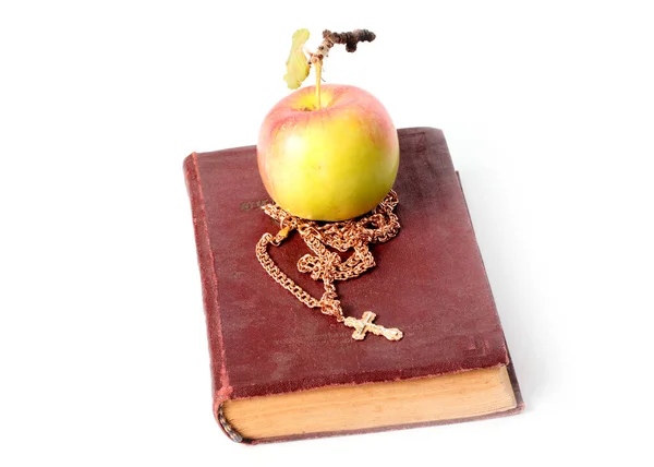 熟したリンゴの横に十字のついたキリスト教の古い本と金の鎖 — ストック写真