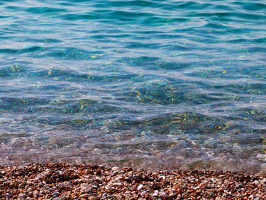 Küçük dalgalar ve denizin kumlu plajı.