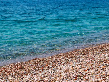 Küçük dalgalar ve denizin kumlu plajı.