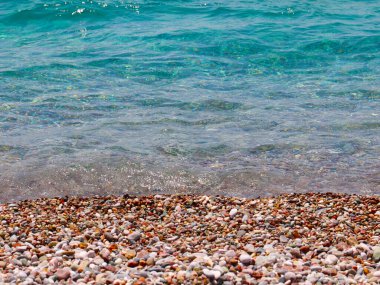 Küçük dalgalar ve denizin kumlu plajı.