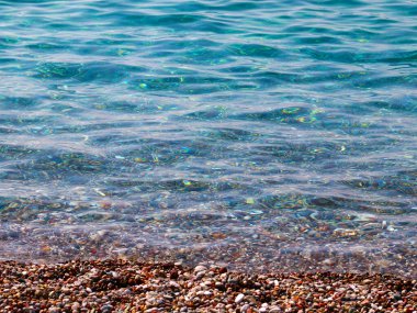 Küçük dalgalar ve denizin kumlu plajı.