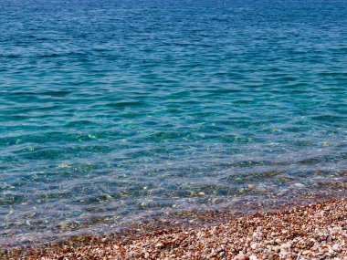 Küçük dalgalar ve denizin kumlu plajı.