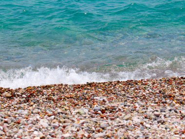 Küçük dalgalar ve denizin kumlu plajı.