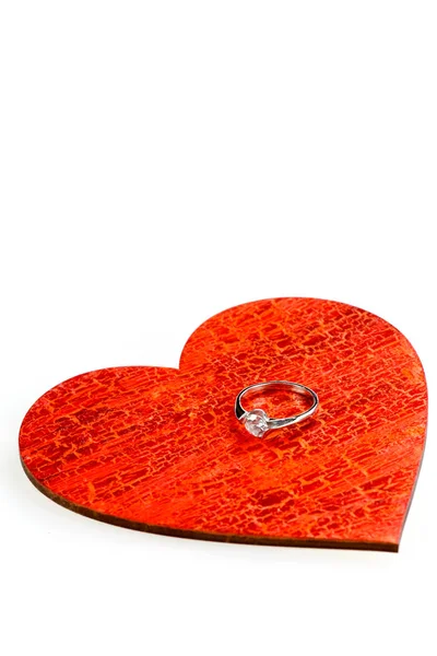 Förlovningsring på ett rött trä hjärta — Stockfoto
