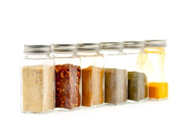 Kuru mutfak baharatları depolamak için kare cam kavanozlar. Sığ alan derinliğine sahip seçici odak.