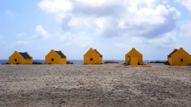 Yellow slave houses on the beach of Bonaire clipart