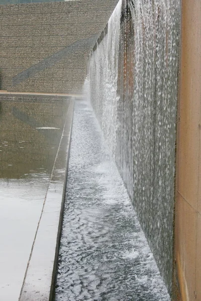 A way to a wall with water outflows over