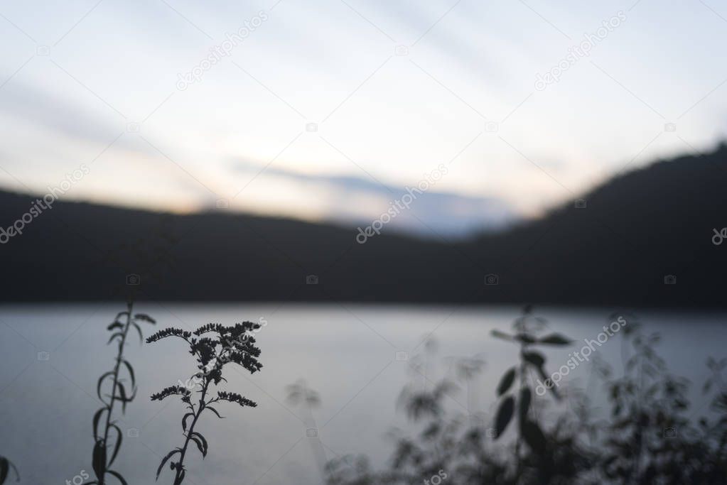 Calm lake in the evening on background