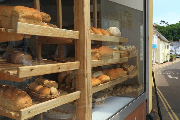 イースト デヴォン シドマス町店の窓にパン表示の焼きたてのパンでいっぱいの棚 — ストック写真