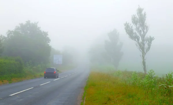 Vehicle on the road on the foggy morning in Devon