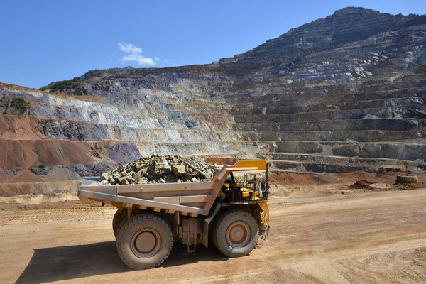 Aerial view of opencast mining quarry with heavy loaded truck