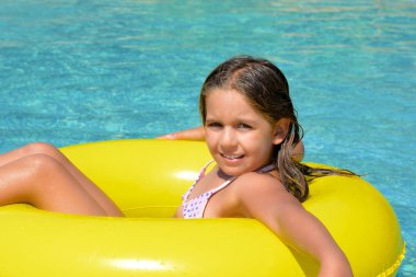 Çok tatlı bir kız, yüzme havuzunda dinleniyor, yaz tatili konsepti.