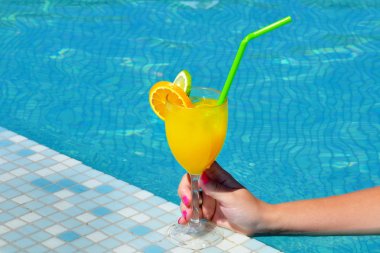 Kadın güzelliğinin kokteyl içki bardak yüzme havuzu tutarak closeup görüntü