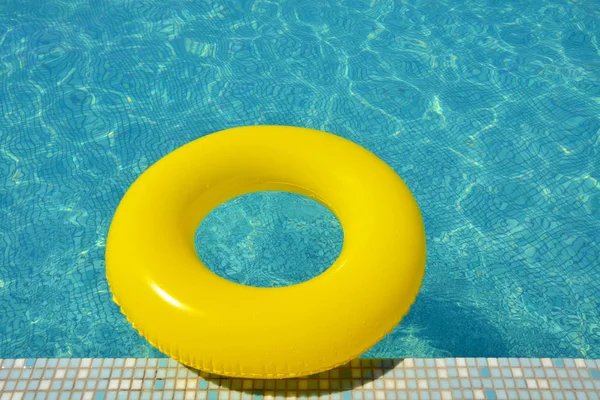 Colorful inflatable tube floating in swimming pool, summer vacation concept