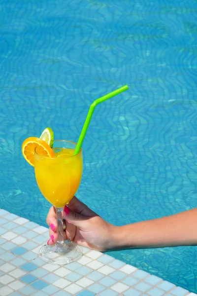 Kadın güzelliğinin kokteyl içki bardak yüzme havuzu tutarak closeup görüntü