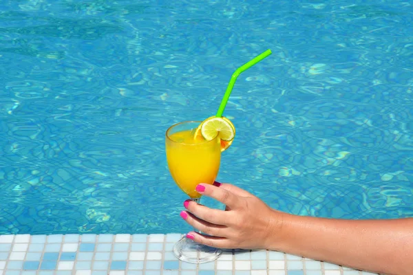 Kadın güzelliğinin kokteyl içki bardak yüzme havuzu tutarak closeup görüntü