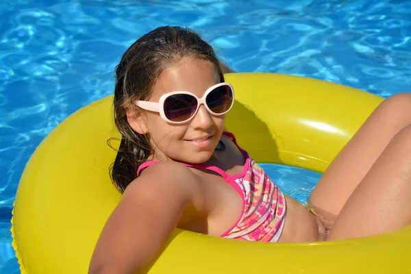 Çok tatlı bir kız, yüzme havuzunda dinleniyor, yaz tatili konsepti.